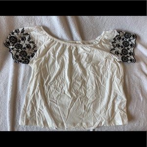White off the shoulder top w/ black floral sleeves